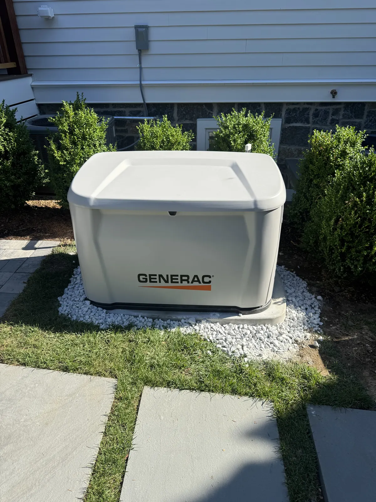 JLC Electrical Contractors LLC Generac standby generator installed by JLC Electrical Contractors on a gravel pad beside a New Jersey home